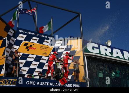 Casey Stoner (AUS) di Ducati Marlboro celebra il suo australiano Moto Grand Vittoria del premio con il compagno di squadra Loris Capirossi (ITA) e Fiat Yamaha Pilota Valentino Rossi (ITA) Foto Stock