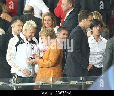 L'allenatore tedesco Joachim Low (r) cammina come il Bastiano della Germania Schweinsteiger parla alla cancelliera tedesca Angela Merkel (c) Foto Stock