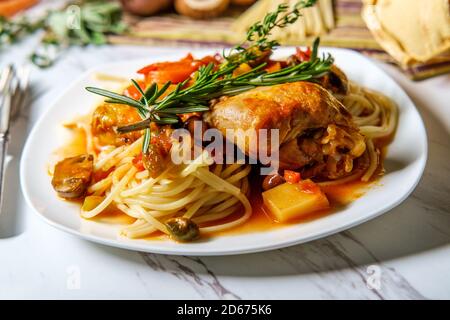 Pollo italiano Cacciatore il cacciatore stufato con spaghetti tagliatelle e crosta di pane Foto Stock