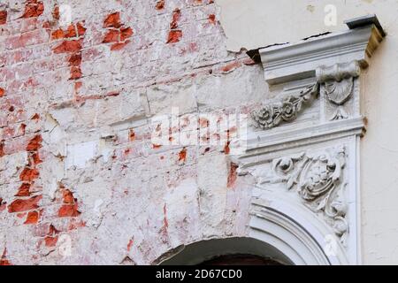 Frammento di facciata con stucco rovinato di un vecchio edificio abbandonato. Foto Stock