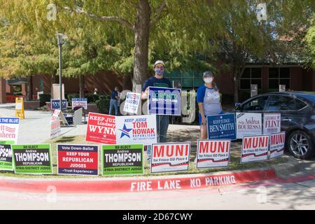 Plano, Stati Uniti. 14 ottobre 2020. La gente tiene i segni di elezione fuori di una stazione di polling a Plano, Texas, gli Stati Uniti, il 14 ottobre 2020. Le prime votazioni nello stato americano del Texas sono iniziate martedì. Credit: Dan Tian/Xinhua/Alamy Live News Foto Stock