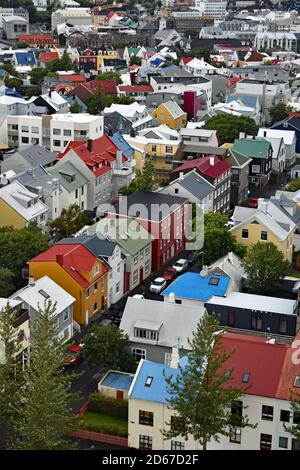 Una vista dalla cima della torre della chiesa di Hallgrimskirkja. File di moderne case scandinave dai colori vivaci possono essere viste attraverso la città di Reykjavik, Islanda. Foto Stock