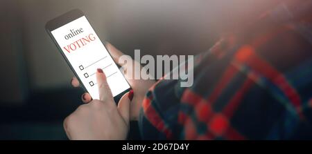 La donna vota online utilizzando il telefono. Concetto di voto e di elezione. Foto Stock