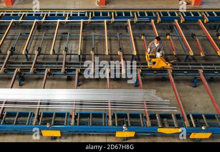 (201015) -- TANGSHAN, 15 ottobre 2020 (Xinhua) -- Foto aerea scattata il 14 ottobre 2020 mostra un membro dello staff che lavora su una linea di produzione del gruppo Tangshan Jinhengtong nella zona di sviluppo economico di Lutai della città di Tangshan, provincia di Hebei della Cina del nord. Negli ultimi anni, le autorità locali della Lutai Economic Development zone di Tangshan hanno spinto avanti il miglioramento e l'agglomerazione industriale delle aziende locali di produzione di componenti per biciclette. Con più di 40 aziende che raggiungono un fatturato annuo di circa 5 miliardi di yuan (circa 745 milioni di dollari USA), i prodotti di componenti di bicicletta hanno fatto Foto Stock