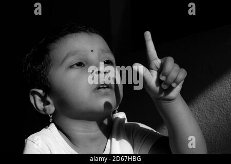 Un colpo vicino di bambino indiano che tiene la mano sul lato in basso luce monocromatica foto, Kalaburagi, Karnataka/India-Ottobre 09 2020 Foto Stock