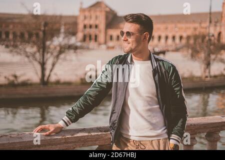 Fuoco selettivo di un uomo sorridente attraente in un città Foto Stock