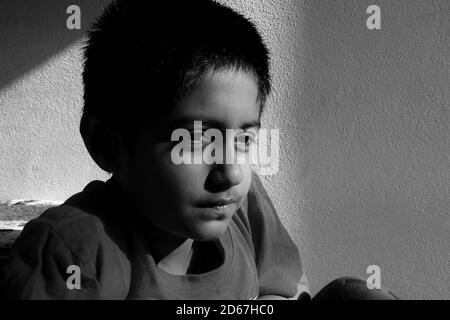 Un colpo vicino della testa del ragazzo indiano che osserva la luce chiave nella foto in bianco e nero del mattino, Kalaburagi, Karnataka/India-ottobre 09 2020 Foto Stock