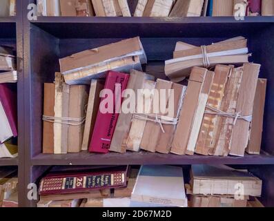 Vecchi libri legati con stringa sugli scaffali Foto Stock