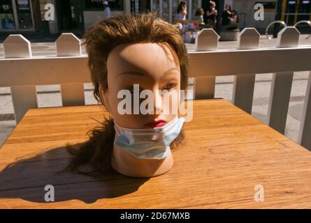 La testa di un manichino in parte indossato sulla maschera chirurgica, all'esterno di un caffè di St Kilda durante il rigido blocco pandemico di Melbourne. Foto Stock