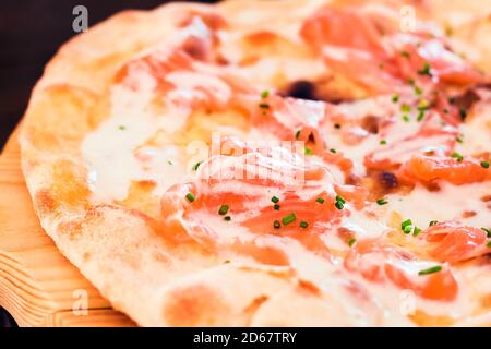 Primo piano di una pizza di salmone affumicata con salsa di yogurt e. erbe (dof poco profonde) Foto Stock