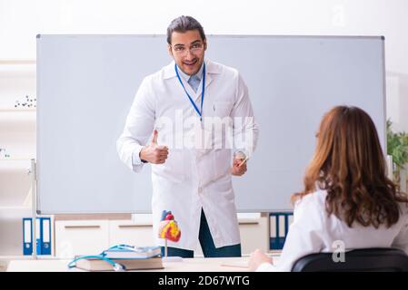 Giovane medico cardiologo maschile e studentessa femminile in classe Foto Stock