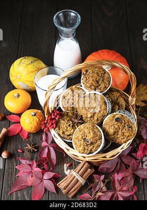 Muffin piccanti di zucca fatti in casa con noci e uvetta, zucche e spezie su sfondo rustico. Cottura in autunno e inverno. Foto Stock