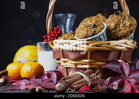 Muffin piccanti di zucca fatti in casa con noci e uvetta, zucche e spezie su sfondo rustico. Cottura in autunno e inverno. Foto Stock