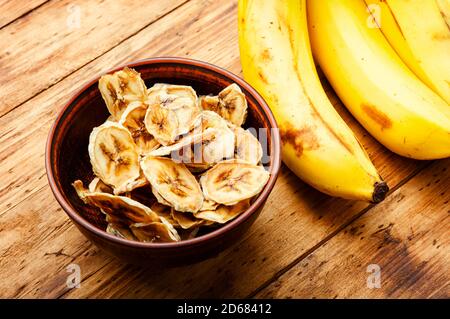 Mature fresche e secche banana.Dried dolce su sfondo di legno Foto Stock
