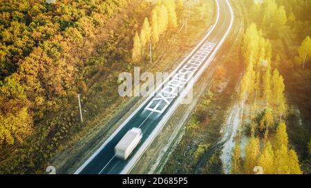 Camion che viaggia su strada all'alba - velocità e concetto di consegna. Sfocatura del movimento. Antenna Foto Stock