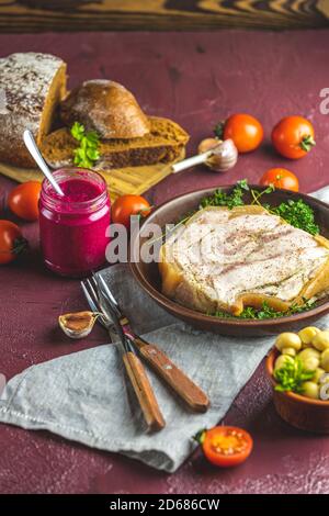 Gustoso lievito di lardo di maiale con salsa al pepe nero e altre erbe e spezie in piatto di ceramica. Tradizionale Natale ucraino, ungherese, polacco Foto Stock