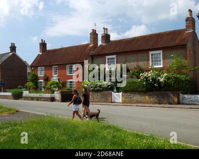 A piedi il cane passato cottage a Bosham, Sussex ovest. Foto Stock