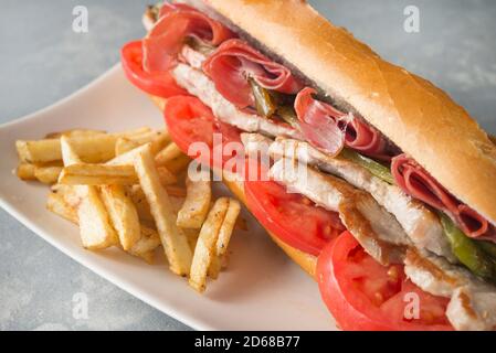 Sandwich Serranito tipico dell'Andalusia con prosciutto, pepe e lombo di maiale alla griglia Foto Stock