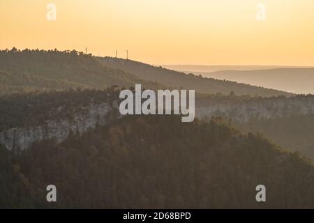 Strati di colline, strada con auto e antenne in cima al crepuscolo Foto Stock