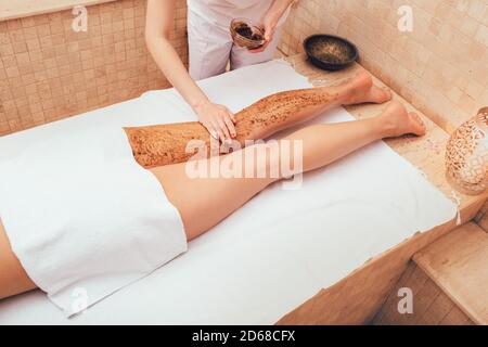 bella donna durante il peeling del corpo al centro benessere. Gode di peeling della pelle, pulizia e rinnovamento della pelle Foto Stock