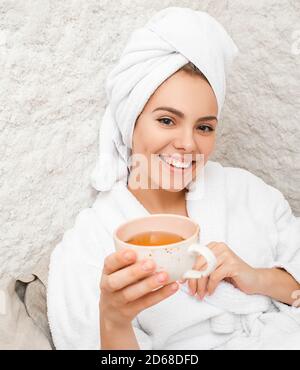 Trattamento con aria salata nella sala sale. Bella donna che beve il tè e che viene trattato nella sala del sale del centro termale Foto Stock