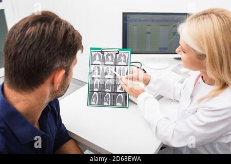 Pulmonologa che mostra un paziente di uomo una scansione TC dei suoi polmoni fibrosi polmonare, dopo il recupero, malattia polmonare Foto Stock