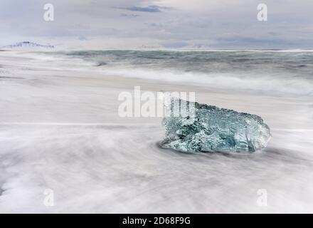 iceberg sulla spiaggia vulcanica nera. Spiaggia dell'atlantico nord vicino alla laguna glaciale Joekulsarlon e ghiacciaio Breithamerkurjoekull nel Vatnajoeku Foto Stock