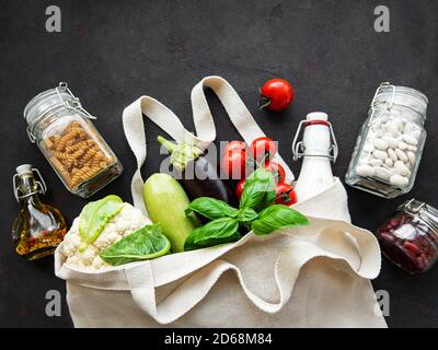 Concetto di zero sprechi. Eco bag con frutta e verdura, vasetti di vetro con fagioli, pasta. Concetto di shopping e cucina eco-friendly, piatto Foto Stock