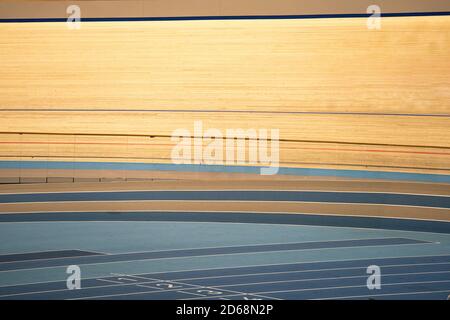 Tracce di un percorso indoor ciclismo velodromo con corso di legno pista da corsa e pavimento blu Foto Stock