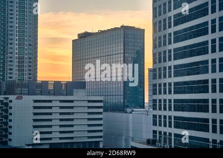 Manila, Filippine - 01 febbraio 2020: Vista serale della città di Makati. I grattacieli contro il sole luminoso. Foto Stock