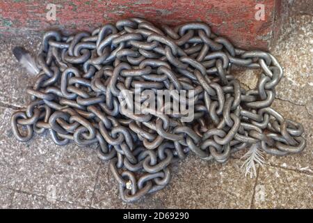 Grande pila di catene in acciaio a contatto con il pavimento Foto Stock