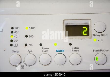Primo piano del pannello di controllo di una lavatrice con pulsanti rotondi da premere per selezionare un ciclo di lavaggio appropriato. Display digitale con contatore Foto Stock