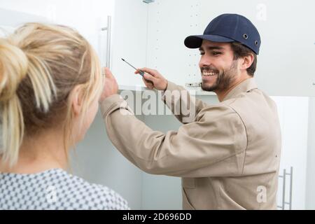 ritratto di un handyman che installa un mobile pensile Foto Stock