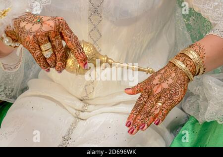 La mano della sposa araba è tatuata con hennè rosso. Tradizioni arabe di nozze Foto Stock