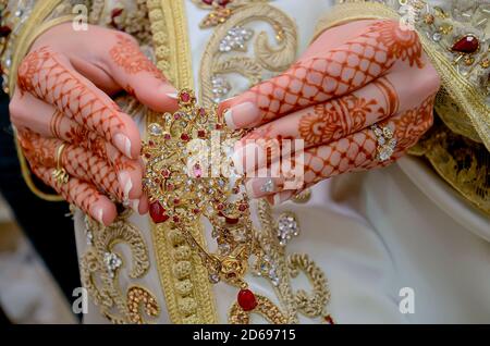 La mano della sposa araba è tatuata con hennè rosso. Tradizioni arabe di nozze Foto Stock