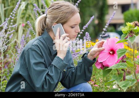 donna bionda sul giardinaggio del telefono Foto Stock