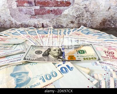 Liras turchi e cento dollari americani. La lira turca si devaluta contro il dollaro americano Foto Stock