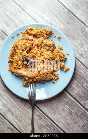 Riso giallo paella servito con gamberi e frutti di mare su un piastra blu Foto Stock