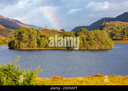 Loch A' Mhuillidh, Glen Strathfarrar nelle Highlands della Scozia. Colori autunnali o autunnali con un arcobaleno sullo sfondo. Orizzontale. Spazio per Foto Stock
