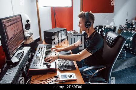 Tecnico del suono nelle cuffie che lavora e mixa musica in interni il monolocale Foto Stock