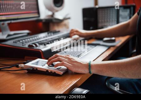 Riproduzione della tastiera midi. Ingegnere del suono che lavora e mixa musica all'interno dello studio Foto Stock