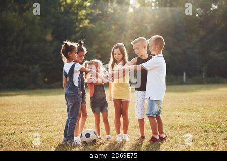 Pronto per il gioco. I bambini più giovani sportivi con palla da calcio si trovano in campo in una giornata di sole Foto Stock