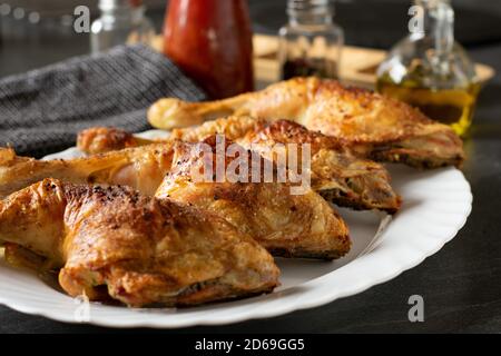 gambe di pollo con pelle croccante su un piatto fuoco selettivo Foto Stock