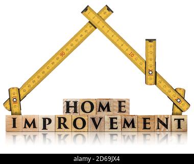 Righello pieghevole in legno giallo a forma di casa e il testo Home Improvement, fatto di blocchi di legno, isolato su sfondo bianco Foto Stock