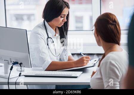 Conversazione attiva. La donna incinta ha consultazione con ostetrista all'interno Foto Stock