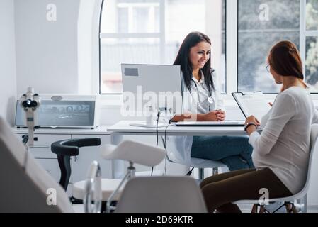 Conversazione attiva. La donna incinta ha consultazione con ostetrista all'interno Foto Stock