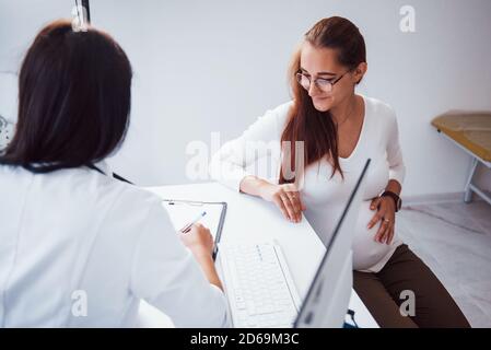 La donna incinta ha consultazione con ostetrista all'interno Foto Stock