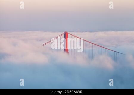 Primo piano al Golden Gate Bridge come coperta di nebbia inferiore la baia di San Francisco in prima serata autunnale, California, USA.