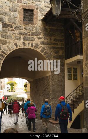 Porta Bozner a Merano, Tirolo del Sud, Italia nel 15 ottobre 2020 immagine colorata con turisti che passano sotto il cancello con maschere di protezione del viso. Foto Stock