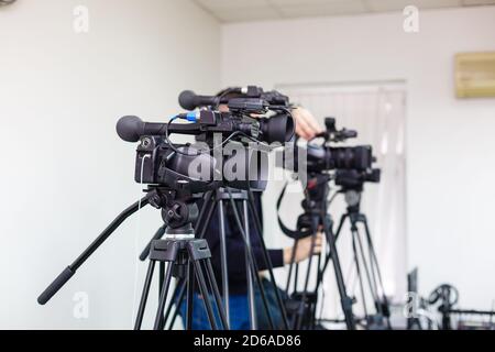 Due videocamere professionali su treppiede. Fotocamera Panasonic. Isolato su sfondo bianco Foto Stock